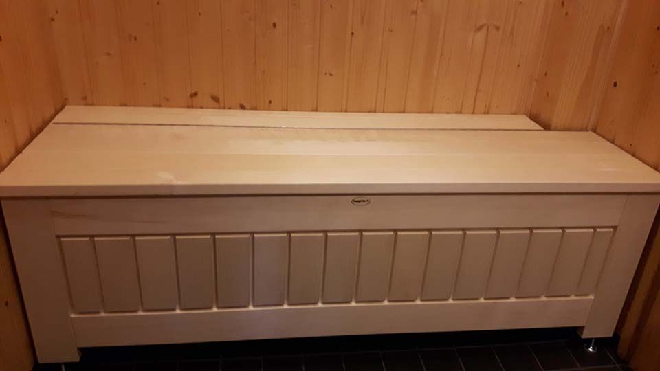 Valkoinen arkkupenkki puisella istuinkannella